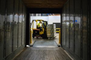 forklift driver hauls boxes at work